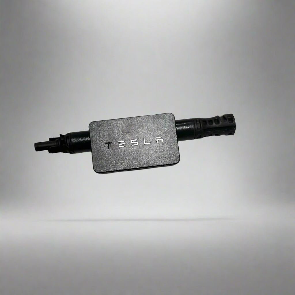 Tesla Mid-Circuit Interrupter (MCI) device with a black enclosure and a solar panel connected via a cable with a black connector.